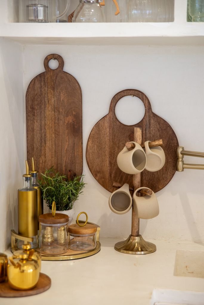 Chic kitchen display featuring wooden cutting boards and ceramic mugs.
